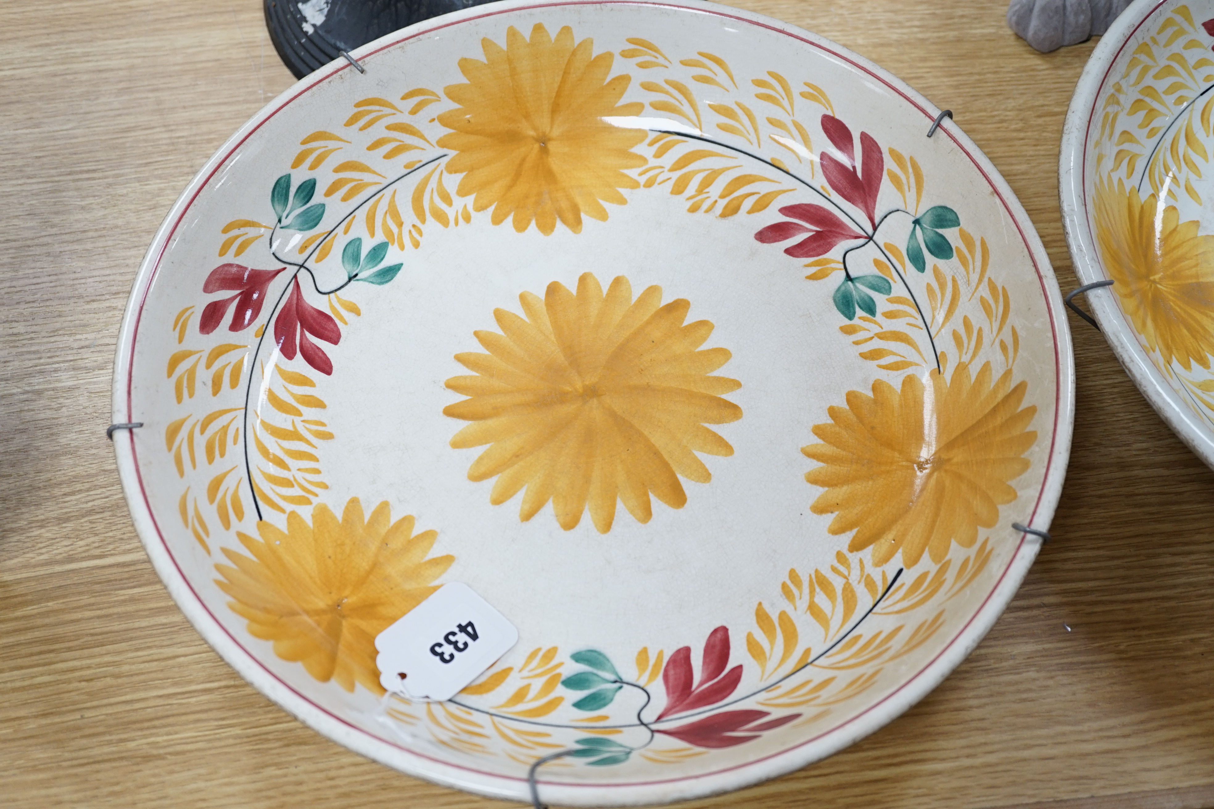 A George Jones & Sons crescent pottery floral wall plate and a similar Staffordshire example, 37cm in diameter